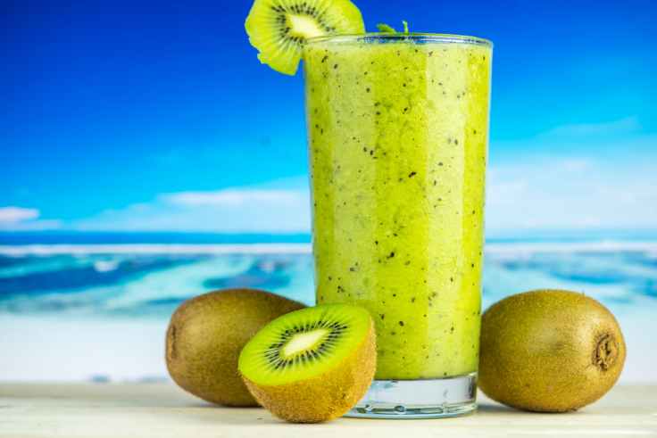 kiwi fruit beside drinking glass filled with kiwi shake